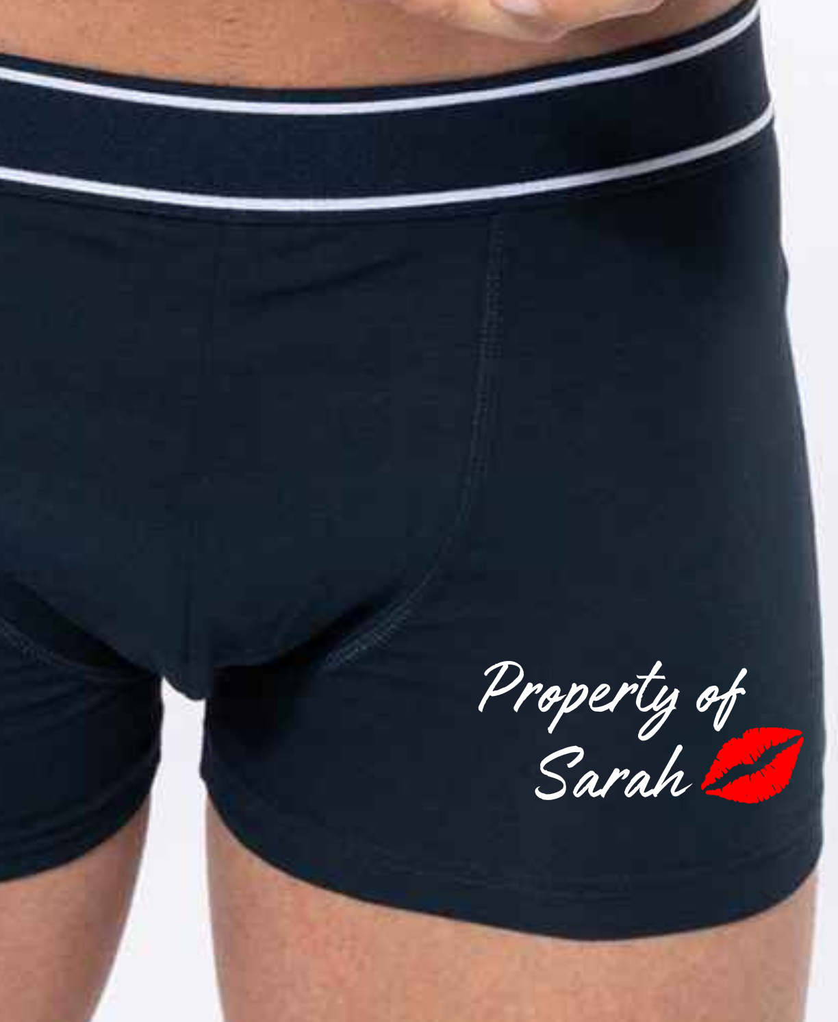 Black boxer shorts printed with an image of lips and the words property of, followed by a name