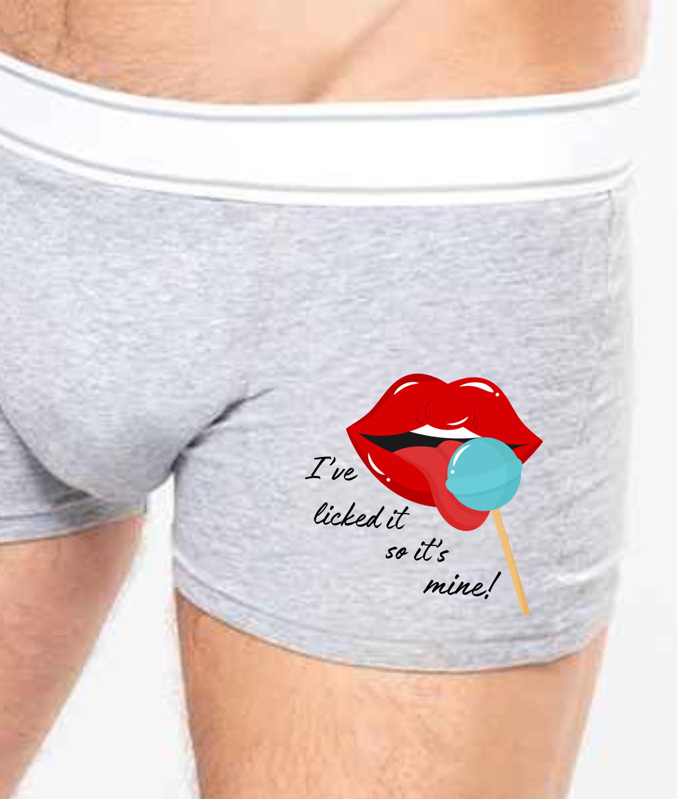 Grey Boxer shorts with a white contrasting waist band. Printed with an image of lips and tongue licking a blue lolly with the words I've licked it so it's mine