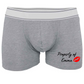 Grey boxer shorts printed with an image of lips and the words property of, followed by a name